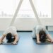 Two individuals practicing yoga in a modern clinic setting, focusing on relaxation and sciatica exercises