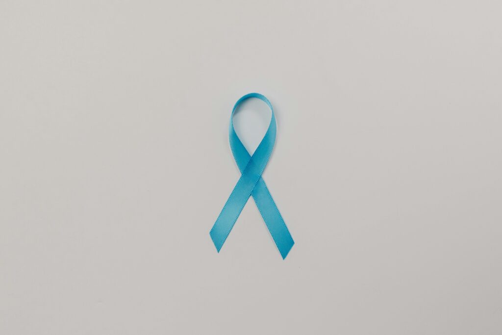 A symbolic blue satin ribbon for cancer awareness against a plain white background.
