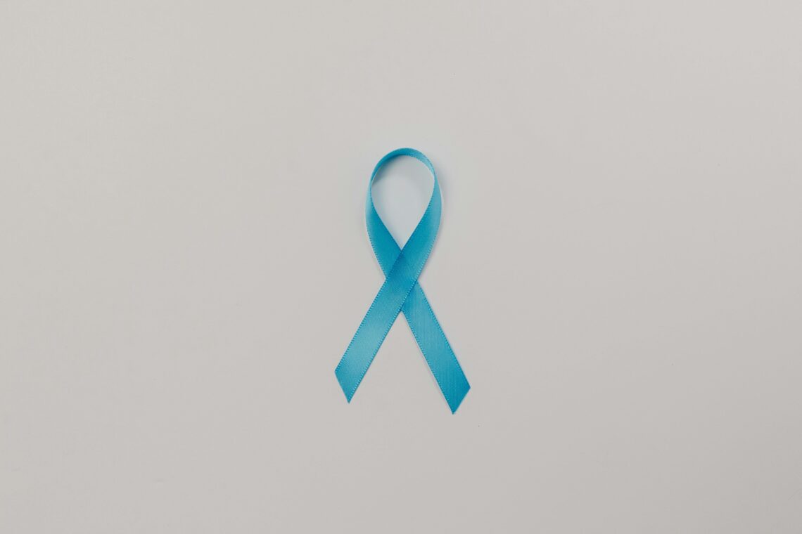 A symbolic blue satin ribbon for cancer awareness against a plain white background.