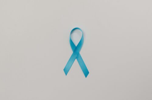 A symbolic blue satin ribbon for cancer awareness against a plain white background.