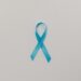 A symbolic blue satin ribbon for cancer awareness against a plain white background.