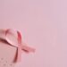 Breast cancer awareness concept with a pink ribbon on a pink October calendar.